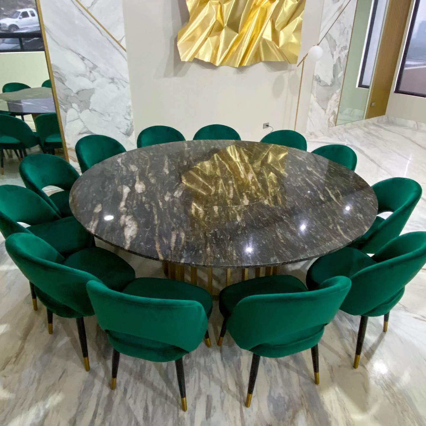 Mesa redonda de piedra con base dorada y sillas esmeralda — Tempus Monterrey