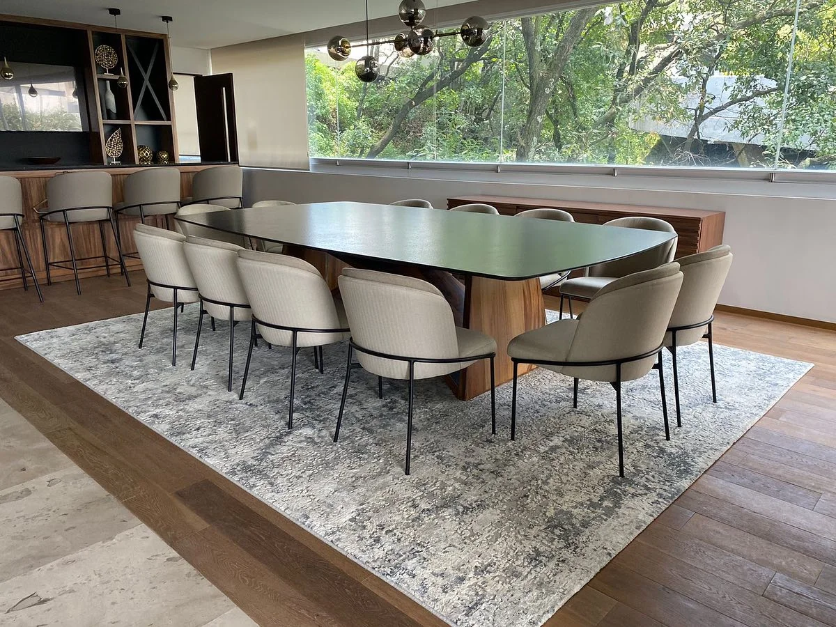 Comedor oval de piedra oscura en penthouse con ventanales — Tempus Monterrey