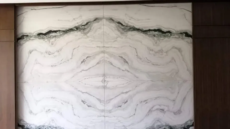 Muro de piedra blanca con vetas oscuras en bookmatch, instalado por Tempus