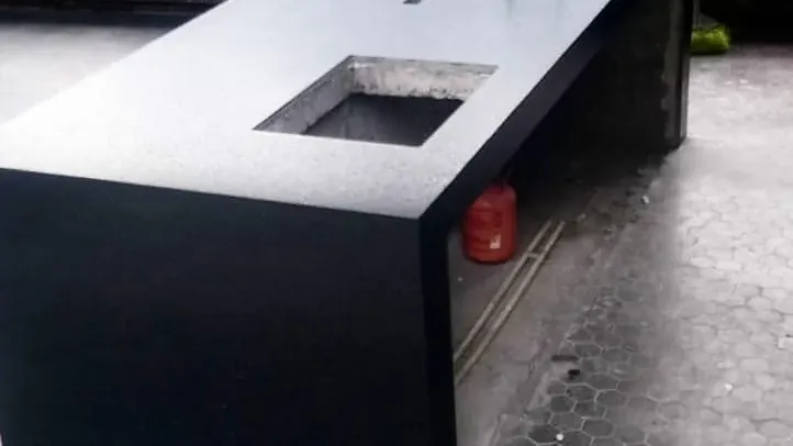 Barra de piedra negra con faldón a inglete que la hace verse gruesa, fabricada por Tempus