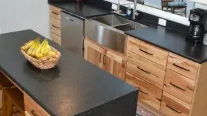 Isla de cocina con cubierta de piedra oscura, instalada por Tempus