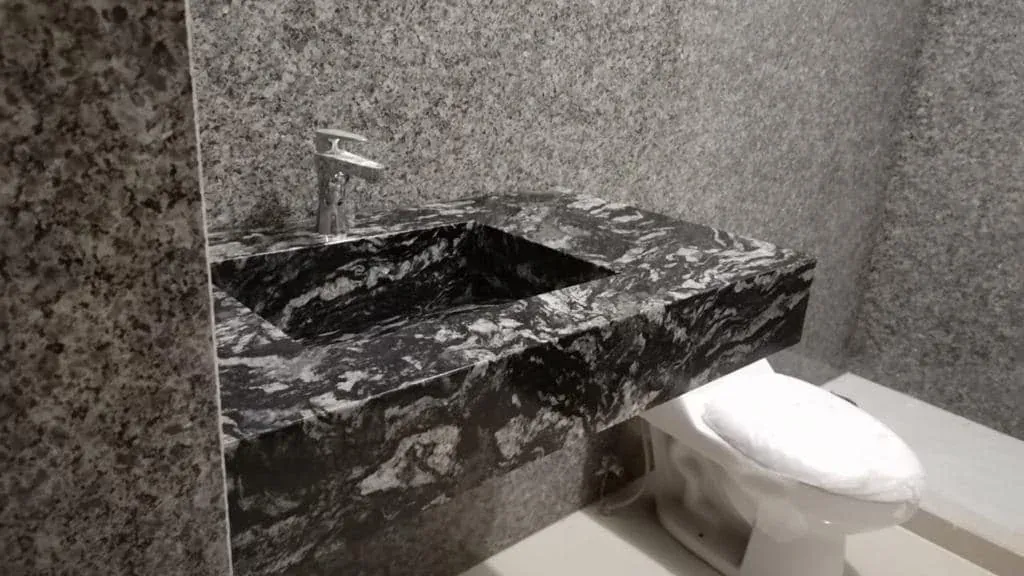 Lavabo de piedra natural oscura con tarja integrada en la misma piedra, fabricado por Tempus