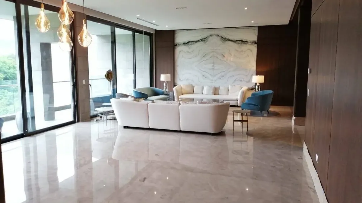 Sala con piso de mármol pulido brillante y muro de piedra en bookmatch, instalados por Tempus