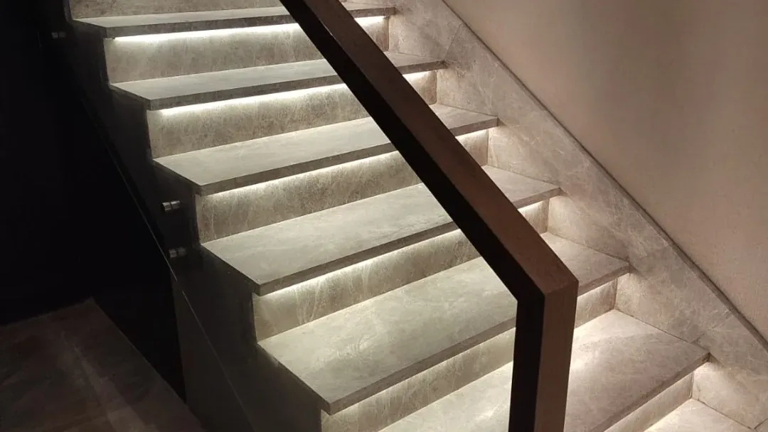 Escalera con huellas de piedra e iluminación, instalada por Tempus