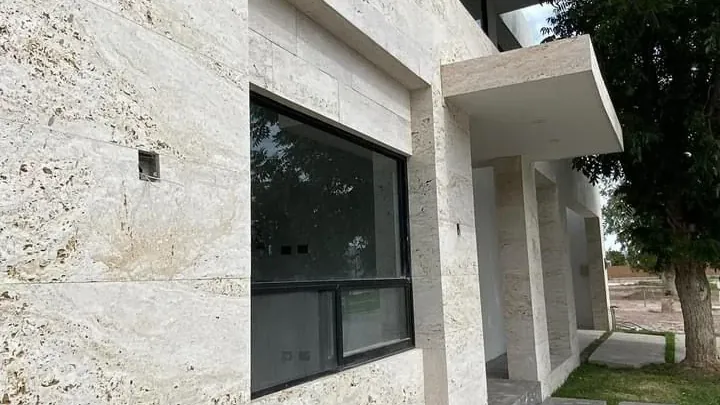 Fachada residencial revestida de travertino, instalada por Tempus