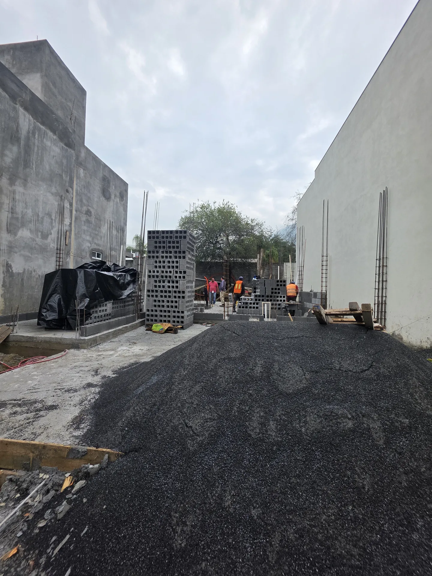 Lote con grava acumulada y blocks apilados al inicio del levantamiento de muros — Casa Las Esmeraldas Tempus