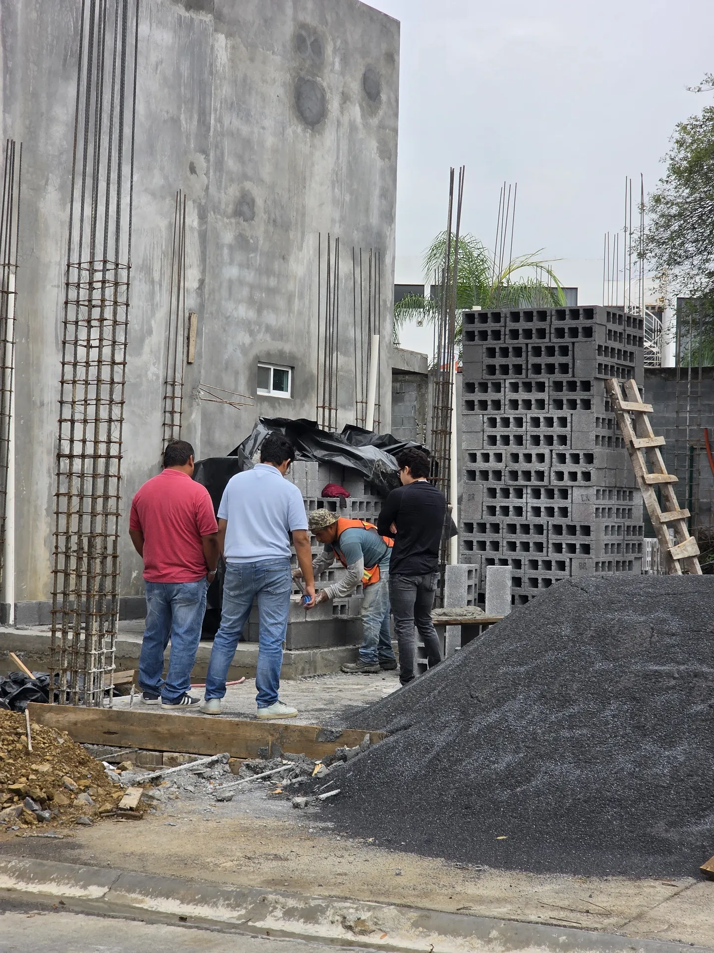 Equipo de albañiles colocando blocks junto a columnas armadas — Casa Las Esmeraldas Tempus Monterrey