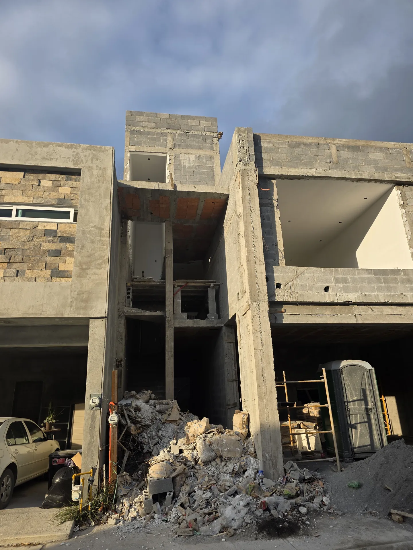 Fachada con dos niveles levantados y escombro al frente — Casa Las Esmeraldas Tempus Monterrey