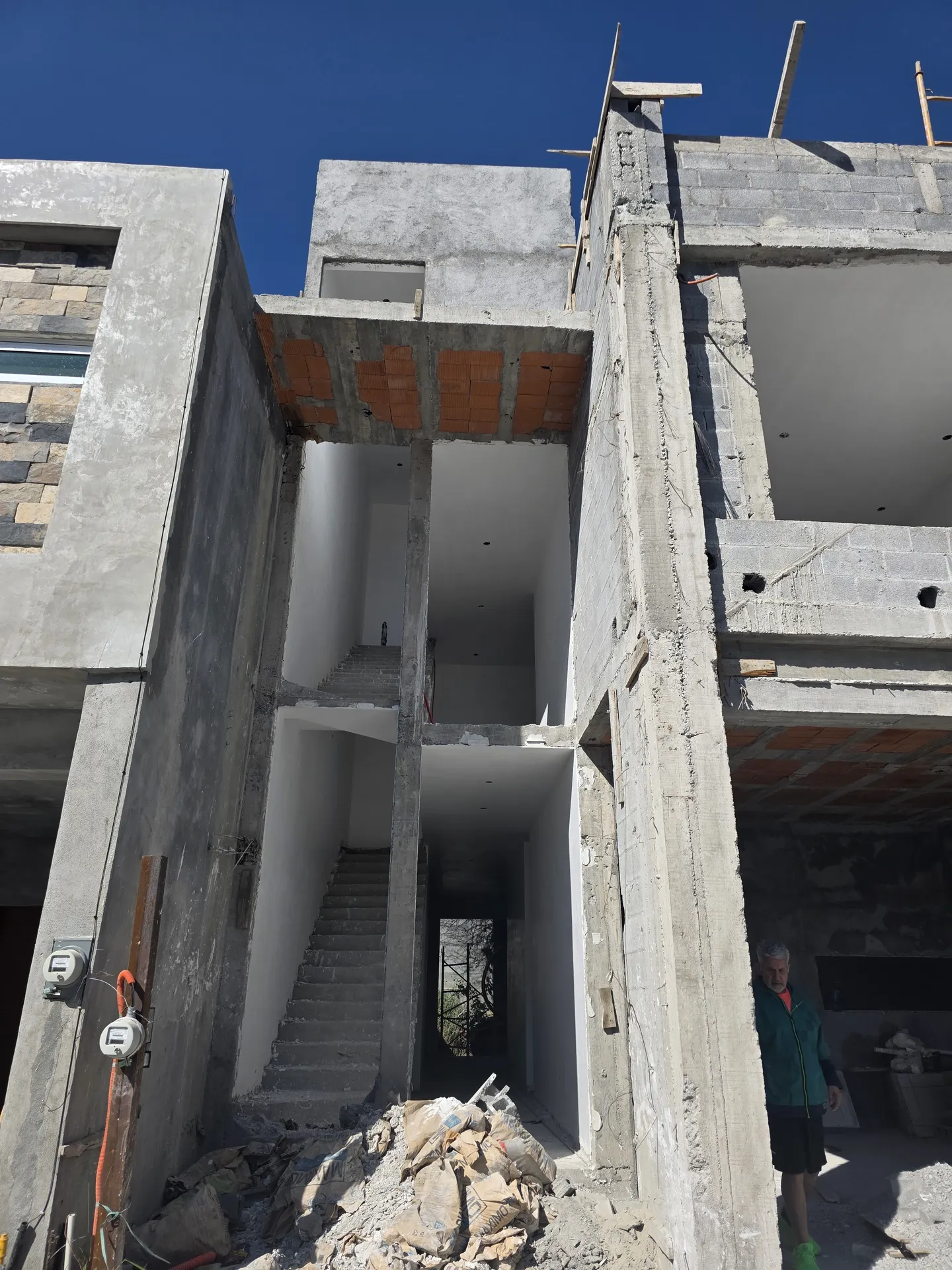 Doble altura interior con escalera de concreto colado y columnas — Casa Las Esmeraldas Tempus Monterrey