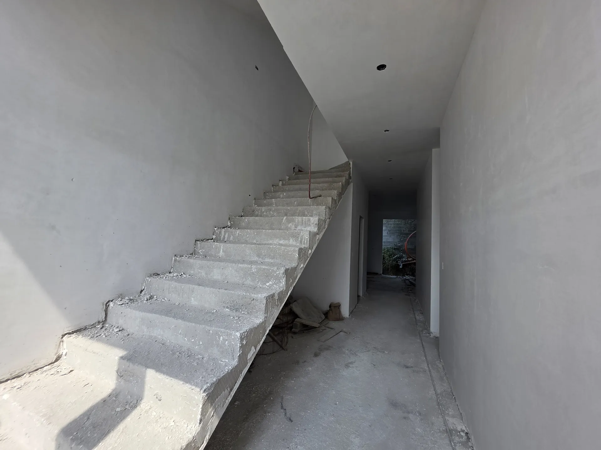 Escalera de concreto colado lista en pasillo de doble altura — Casa Las Esmeraldas Tempus Monterrey