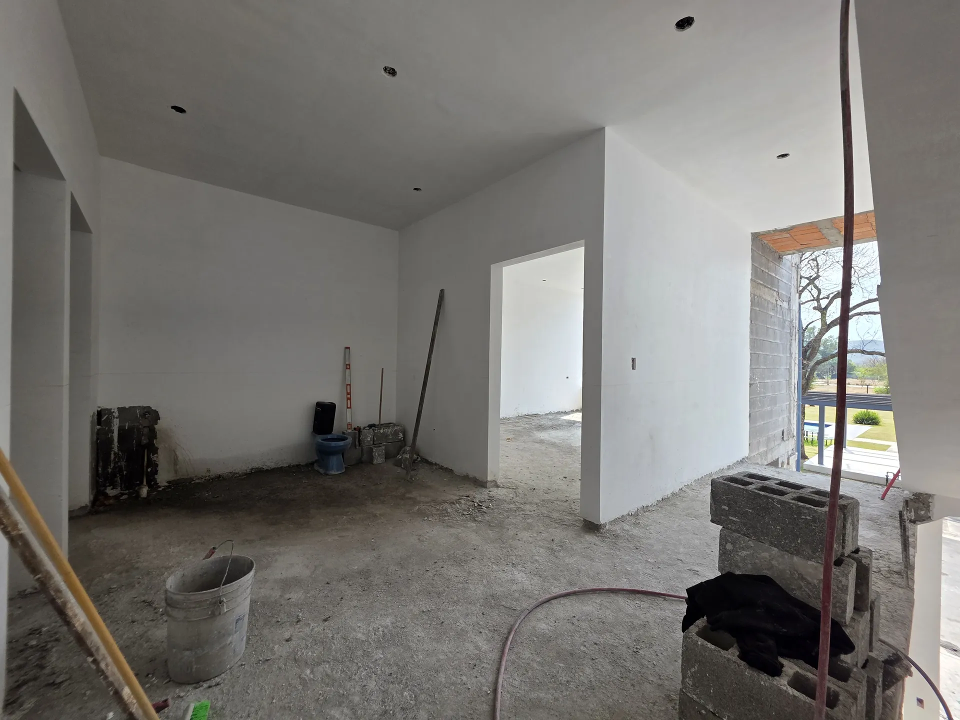 Habitación interior con muros aplanados blancos y ventana al jardín — Casa Las Esmeraldas Tempus