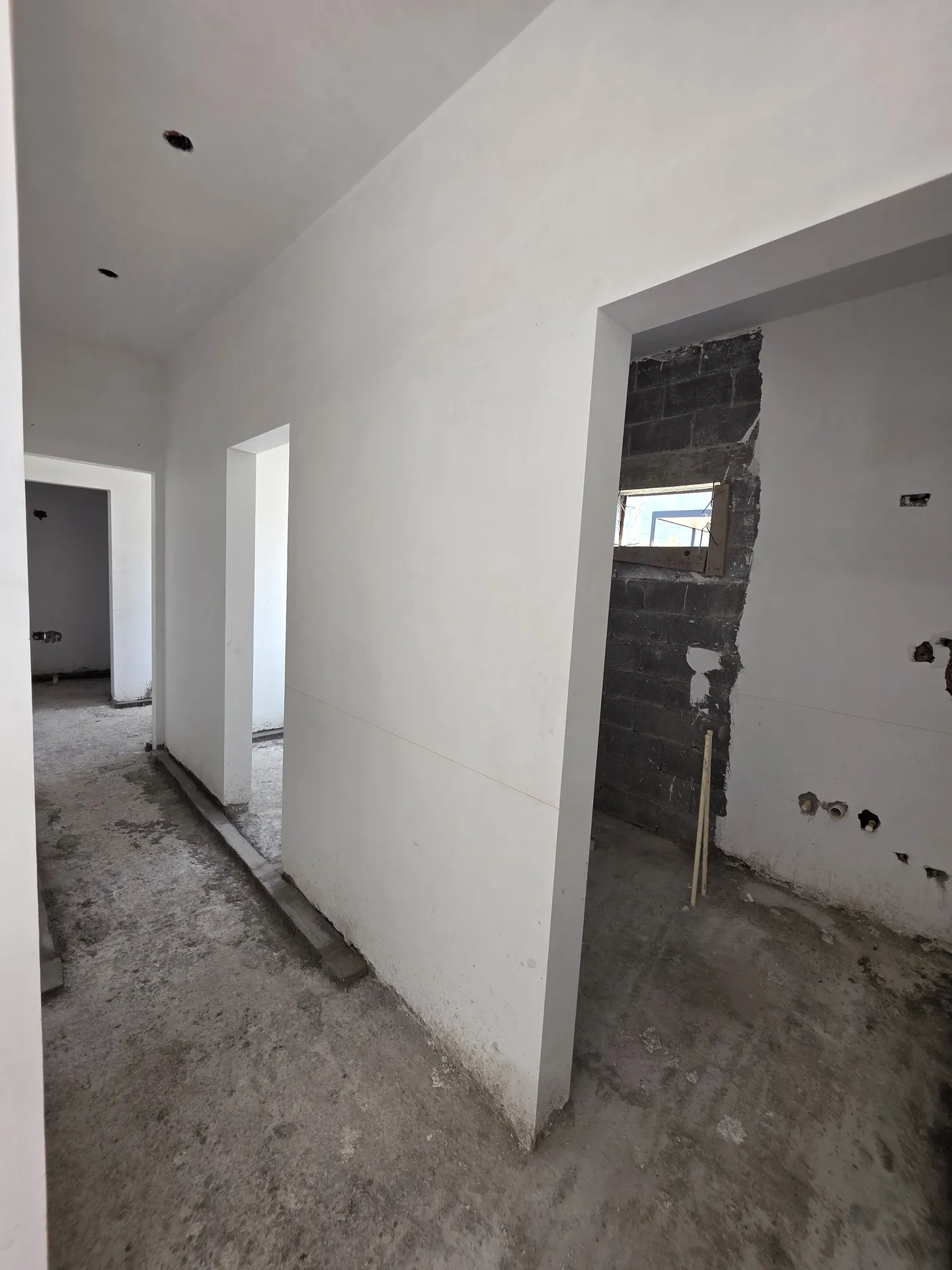 Pasillo interior con muros aplanados y accesos a habitaciones — Casa Las Esmeraldas Tempus Monterrey