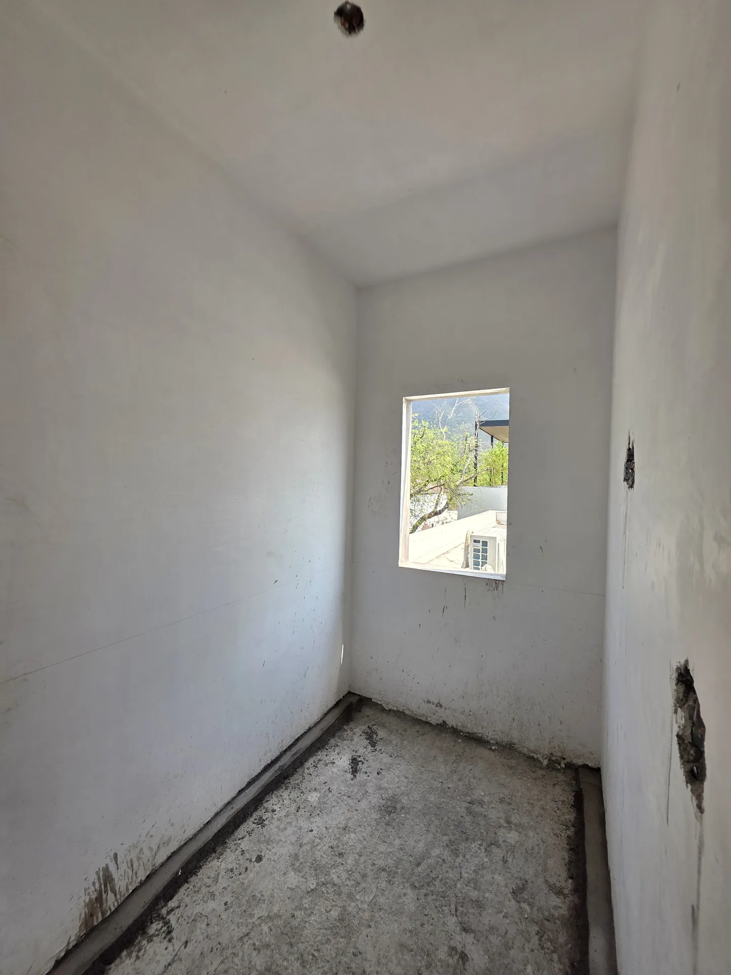 Cuarto aplanado blanco con ventana cuadrada hacia exterior — Casa Las Esmeraldas Tempus Monterrey