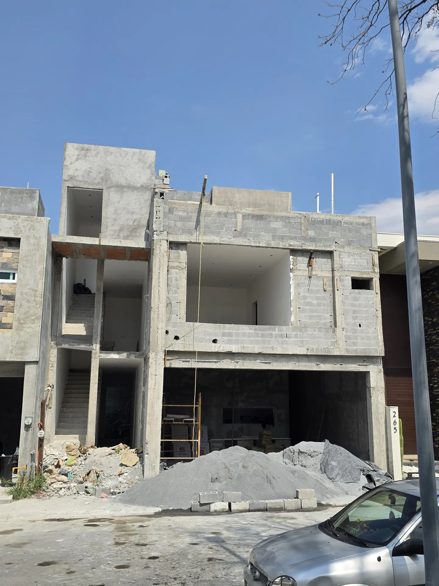 Fachada con cochera y grava acumulada al frente — Casa Las Esmeraldas Tempus Monterrey
