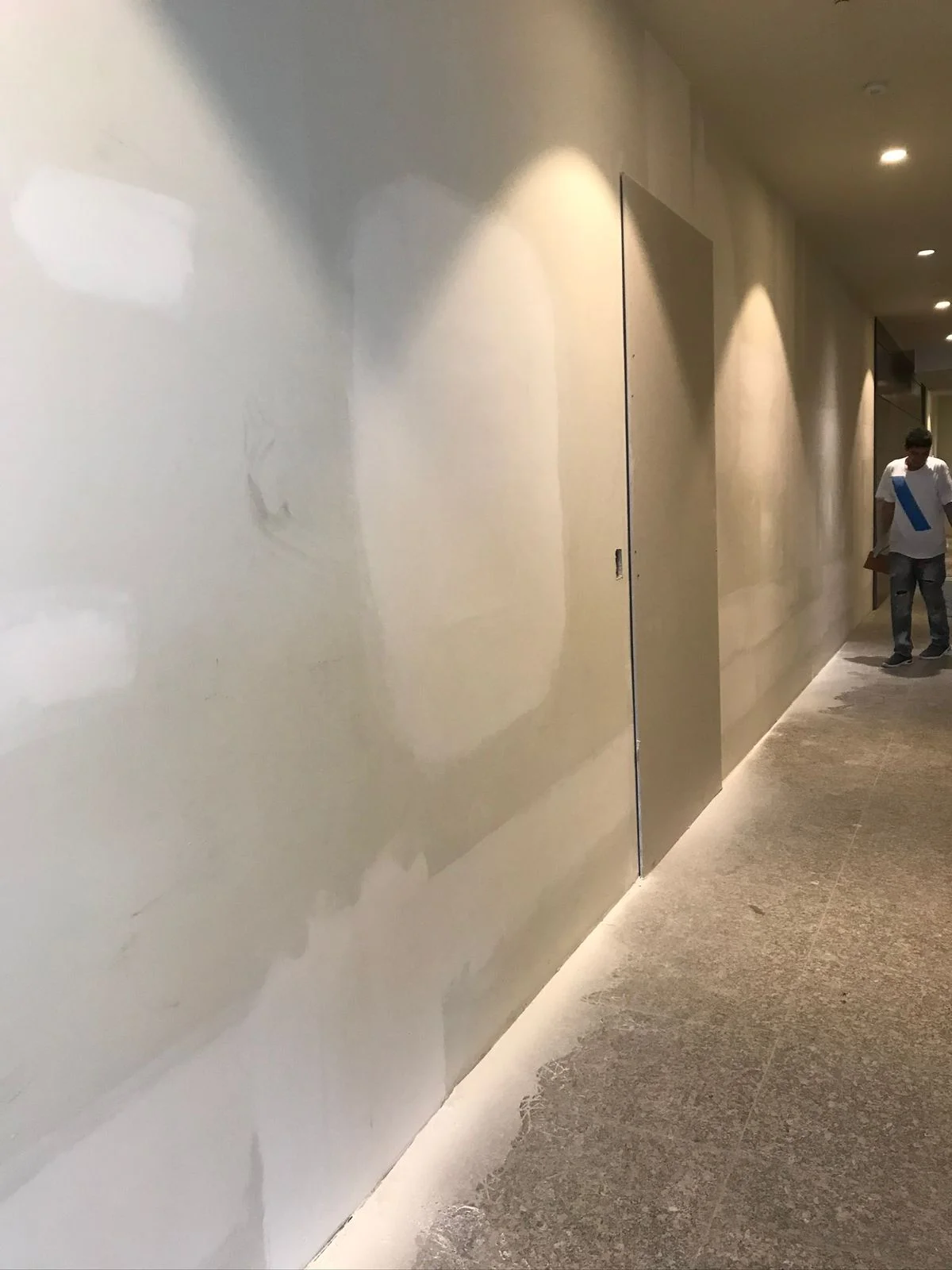 Pasillo terminado con luminarias spot encendidas y muros sin pintar — Altos del Roble Tempus