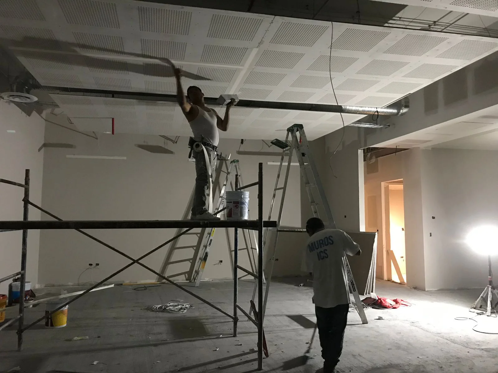 Trabajador en escalera resanando plafón con desnivel — Altos del Roble Tempus Monterrey