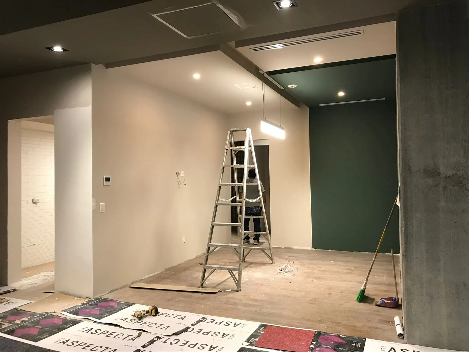 Oficinas en proceso con pared verde oscuro pintada y escalera de obra — Altos del Roble Tempus