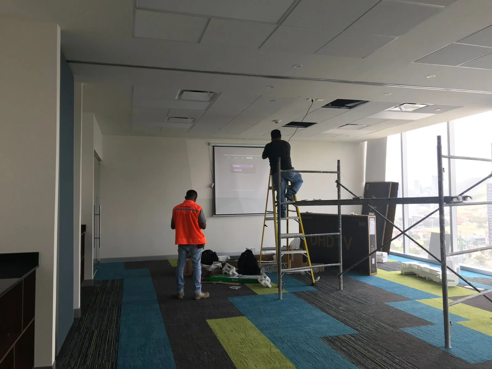 Sala de capacitación con pantalla de proyección, instalación de proyector y alfombra geométrica — Altos del Roble Tempus