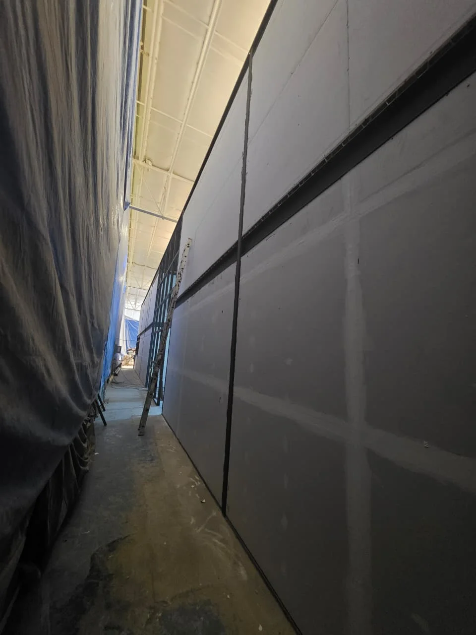 Muros divisorios de tablaroca con cortina protectora azul lateral — Grupo Hydro Tempus Monterrey