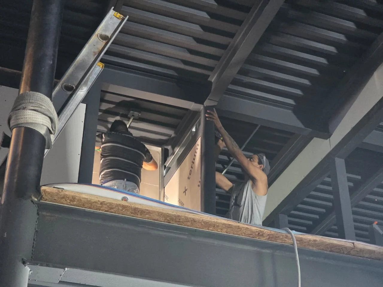 Instaladores en altura colocando placa Glasroc X bajo techumbre de losacero — Grupo Hydro Tempus