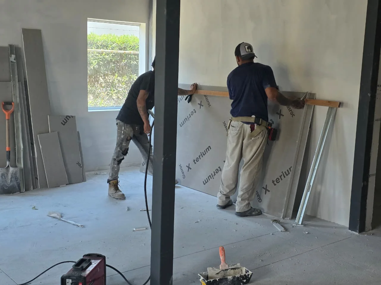 Trabajadores instalando placa Glasroc X antimoho sobre estructura de columna — Grupo Hydro Tempus