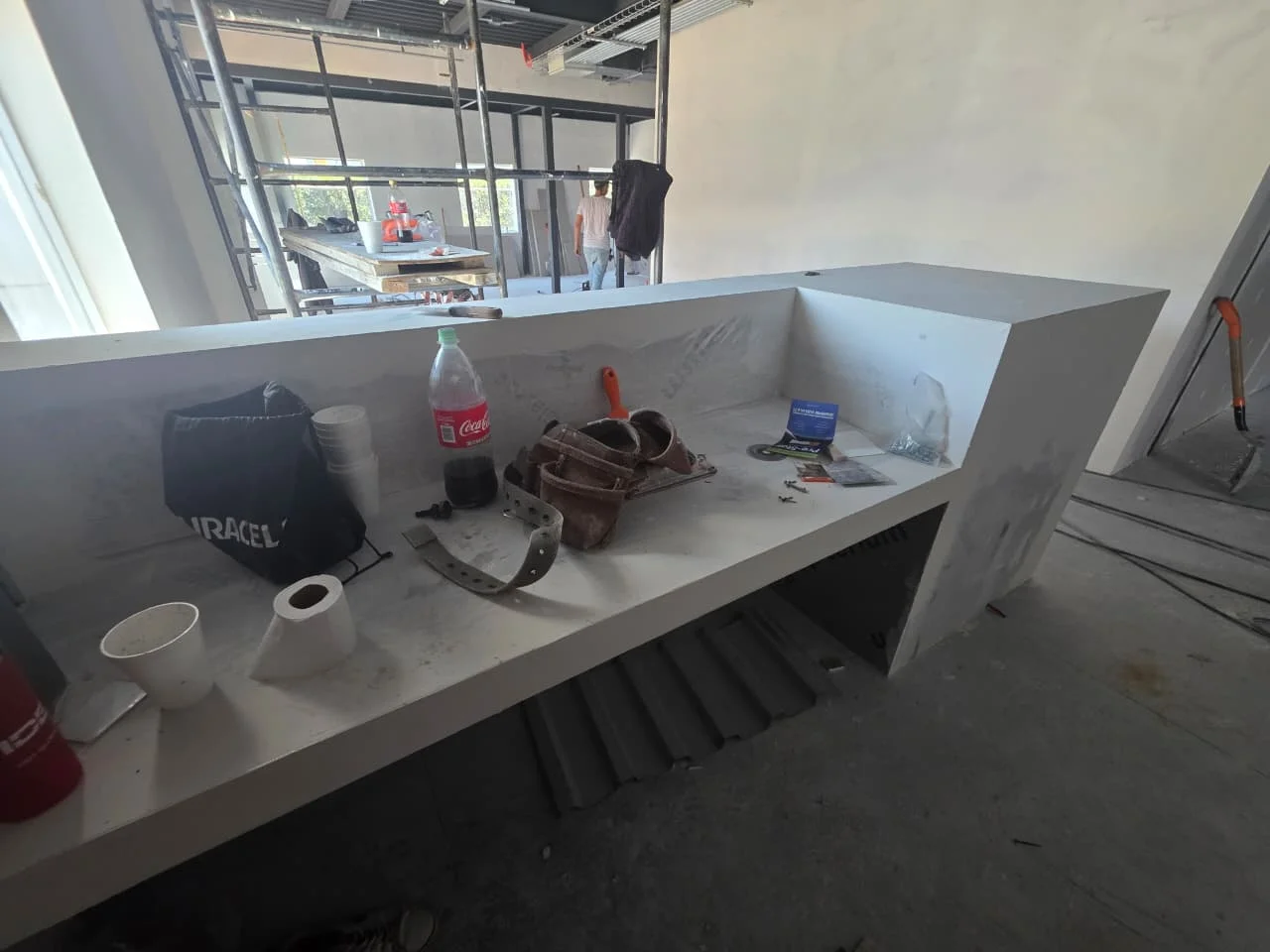 Barra de tablaroca acabada con herramientas y oficina industrial al fondo — Grupo Hydro Tempus