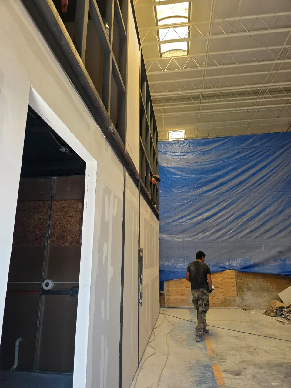 Trabajador frente a muro de tablaroca de doble nivel con cabezal de perfilería — Grupo Hydro Tempus Monterrey