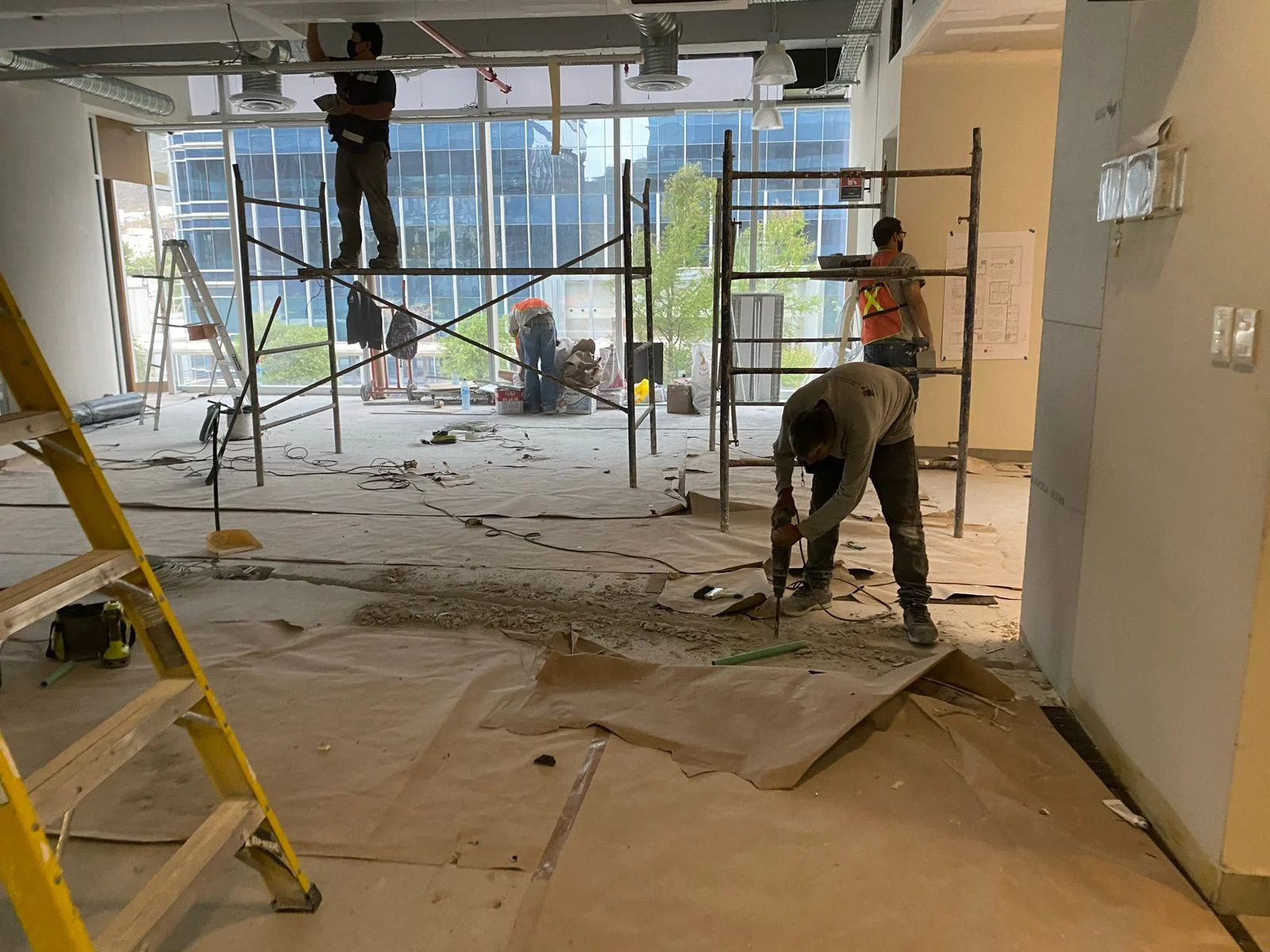 Equipo de trabajadores en demolición de piso con vista a edificio corporativo — Nórdika Business Center Tempus