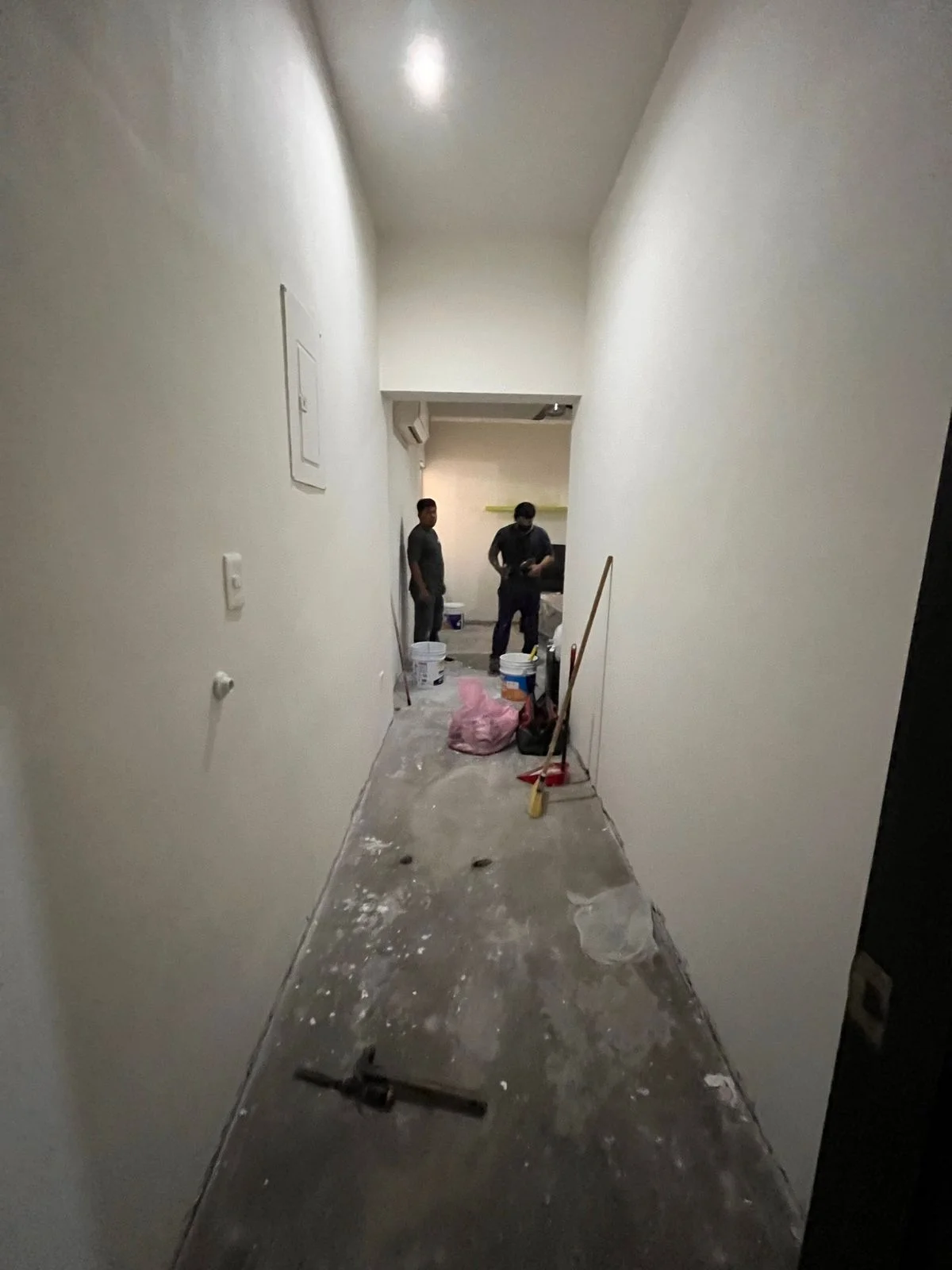 Pasillo angosto con muros aplanados y trabajadores al fondo — Nórdika Business Center Tempus Monterrey