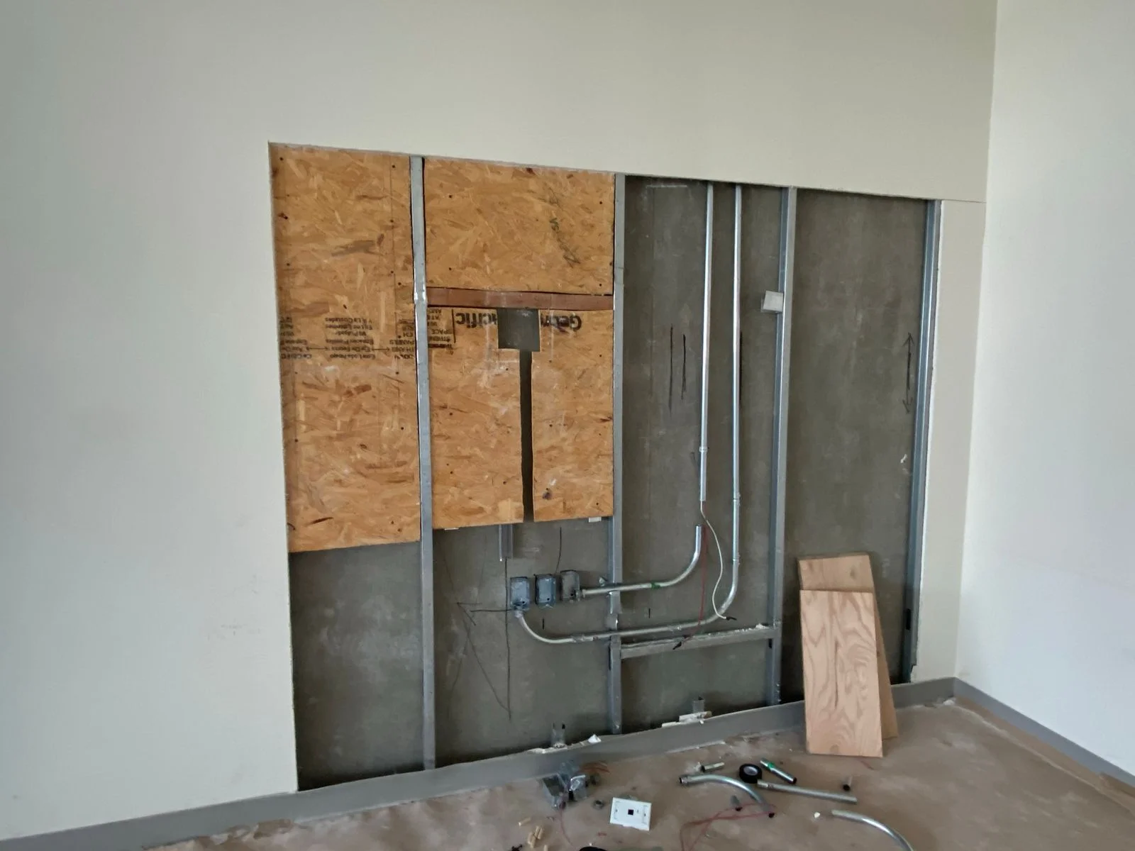 Detalle de muro con preparación eléctrica e hidráulica entre OSB y perfilería metálica — Nórdika Business Center Tempus