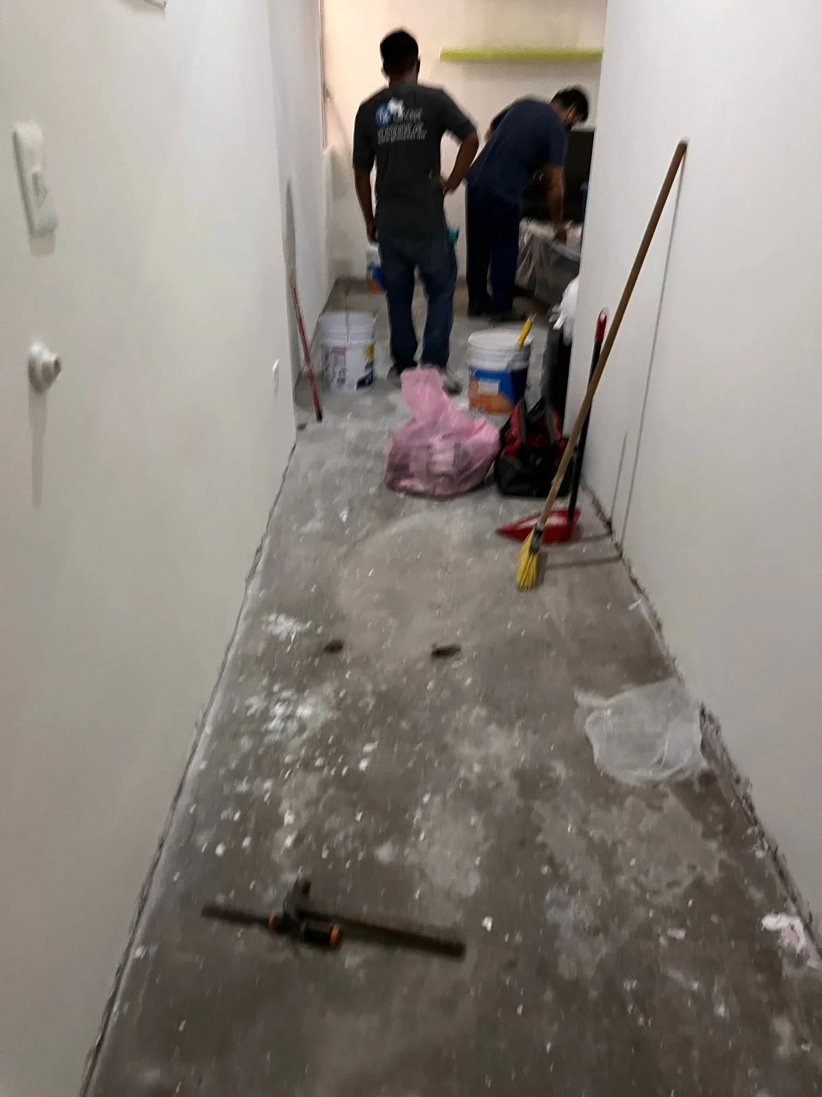 Pasillo en demolición con escombros, herramientas y nivel láser verde en el piso — Nórdika Business Center Tempus