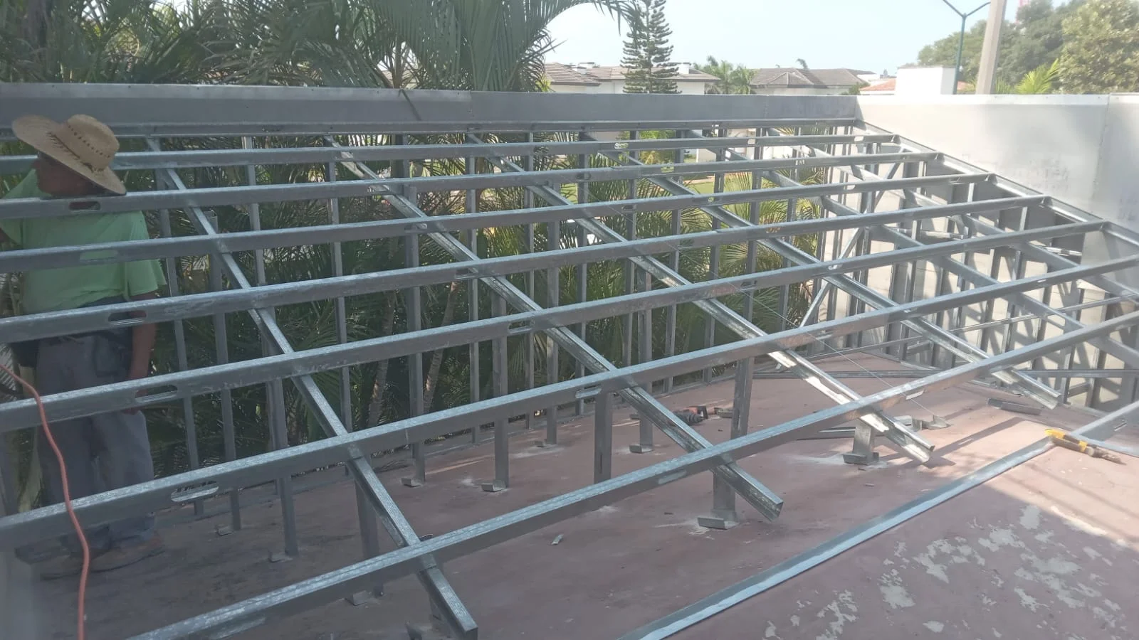 Trabajador armando estructura de techumbre con perfilería metálica galvanizada — Privada Montealto Tempus