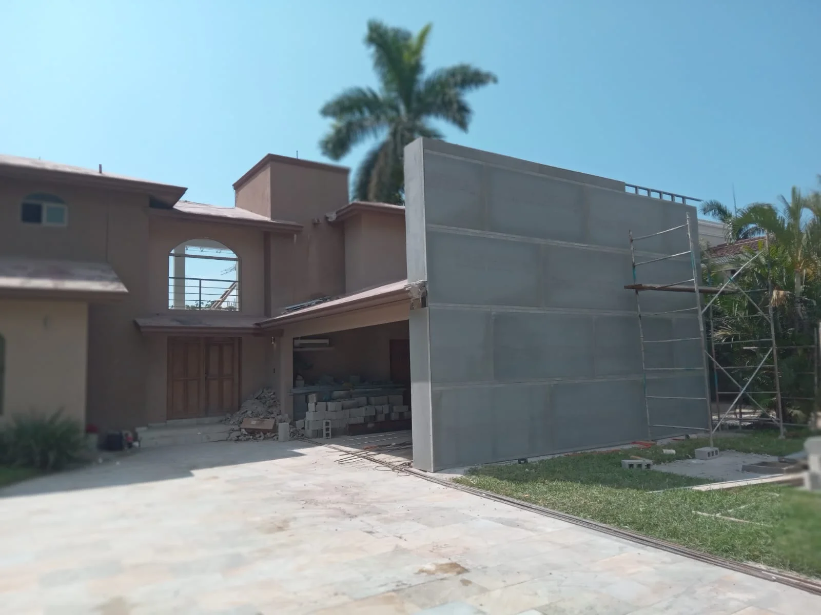 Fachada residencial existente con nueva ampliación de muro panelado y andamios — Privada Montealto Tempus