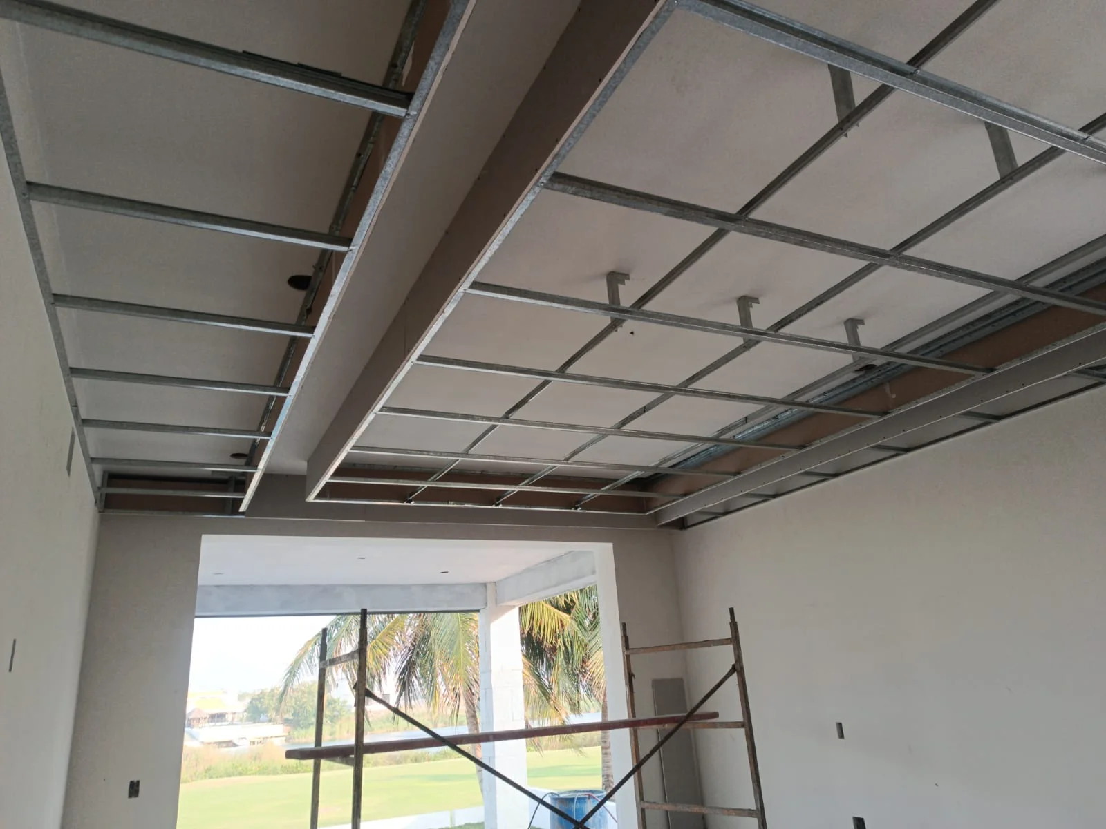 Plafón con desnivel rectangular en construcción con perfilería galvanizada y vista a palmera — Privada Montealto Tempus