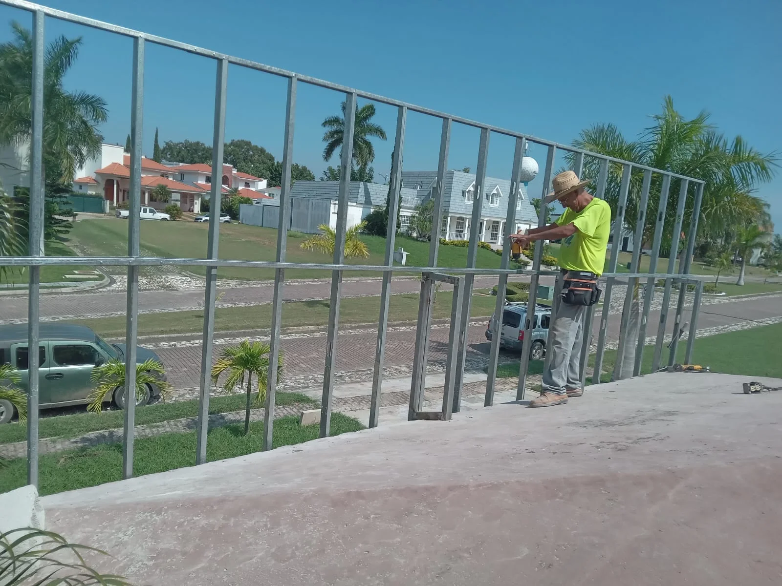 Trabajador instalando barandal de herrería en terraza con vista a privada residencial — Privada Montealto Tempus