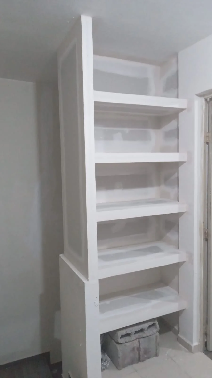 Librero empotrado de tablaroca con 6 niveles de estantes asimétricos terminado en blanco — Privada Montealto Tempus